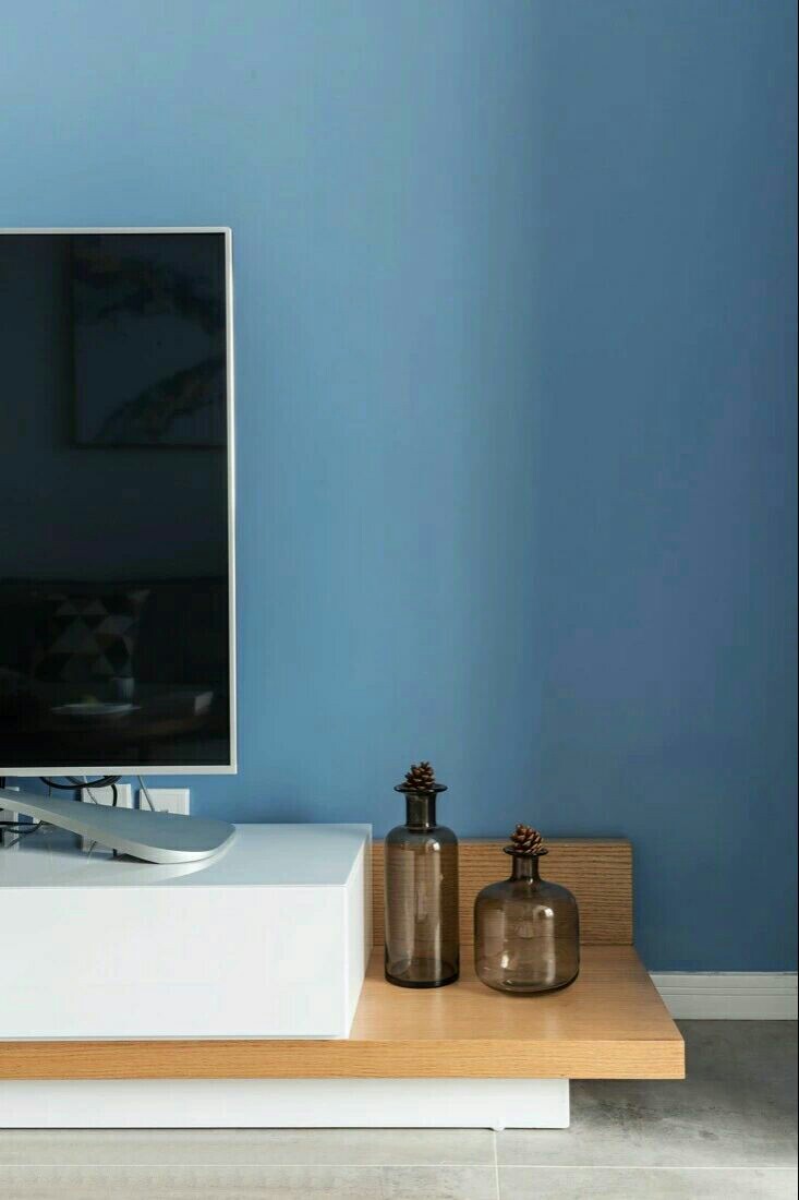 客厅墙面通过白色与灰蓝色的经典搭配营造出现代简约的理性之美。