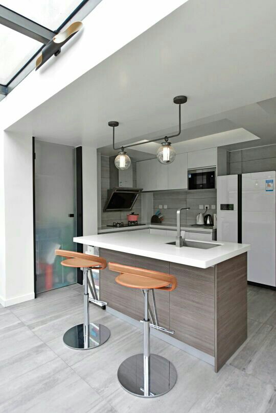 开放式的厨房,打通生活阳台,中间隔了一个中岛台,搭配2张吧椅