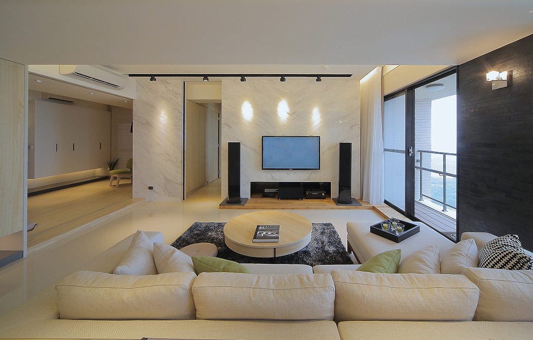 设计在大空间中,以转角沙发,客厅圆桌,内墙灯带内嵌墙柜.