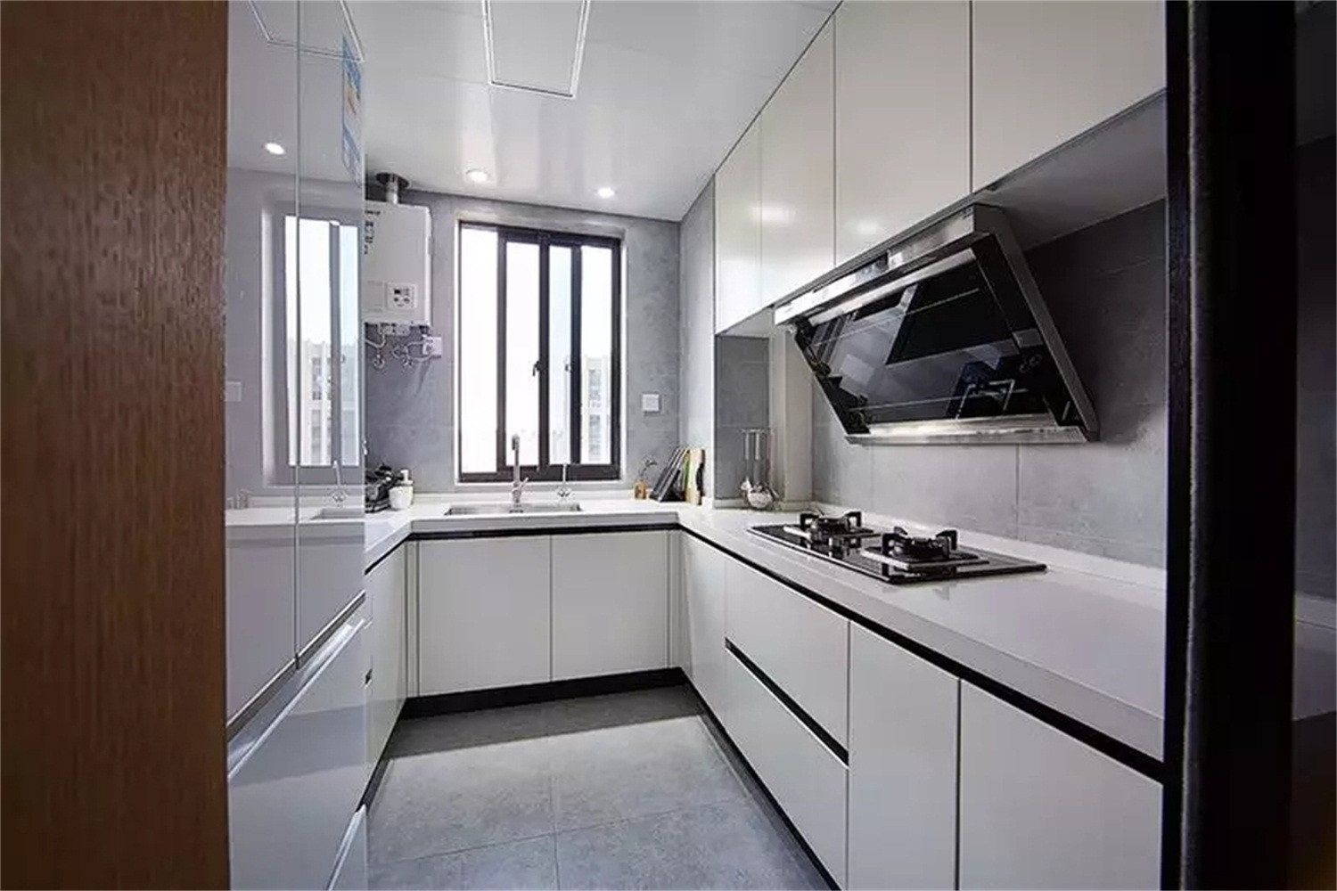 白色橱柜让厨房看起来明亮宽敞,浅灰色的地砖和墙砖