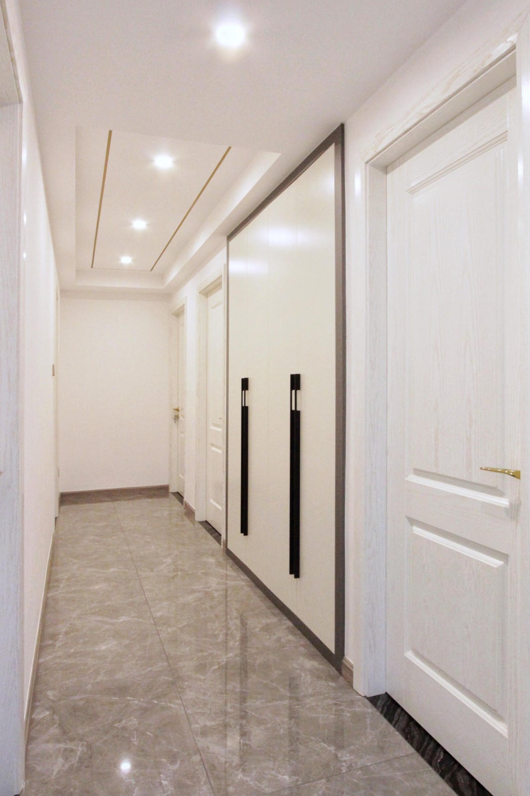 走廊与玄关相通,色调与风格一致,更讲究空间整体性,长廊向室内不断