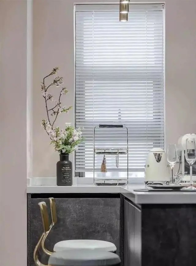 白色台面,射灯设计,后面的墙壁内嵌,做出壁龛,形成装饰架,让餐厅低调