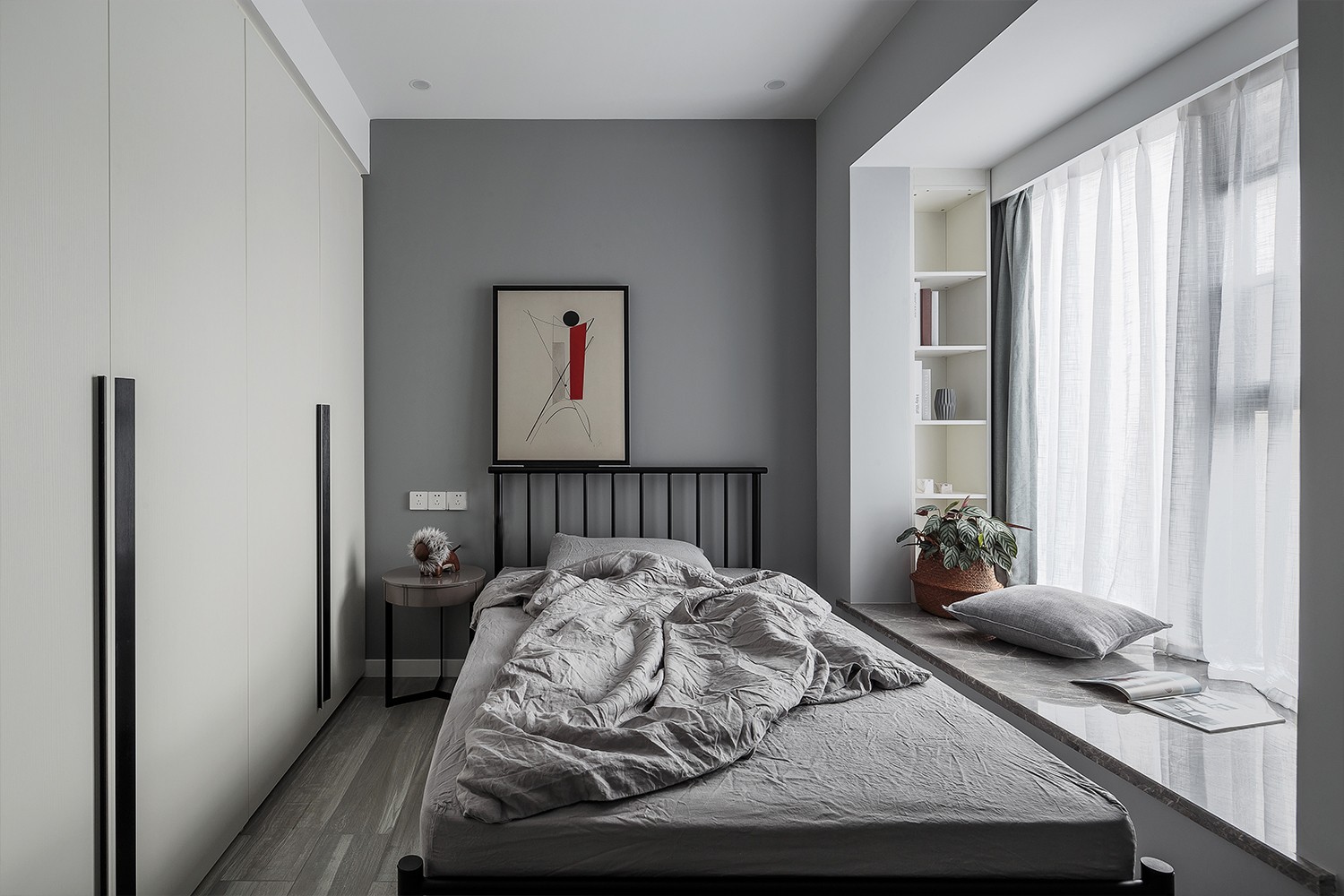 灰色墙与地面砖,床单,结合黑色床与床头柜,床头墙还挂着一副横幅装饰