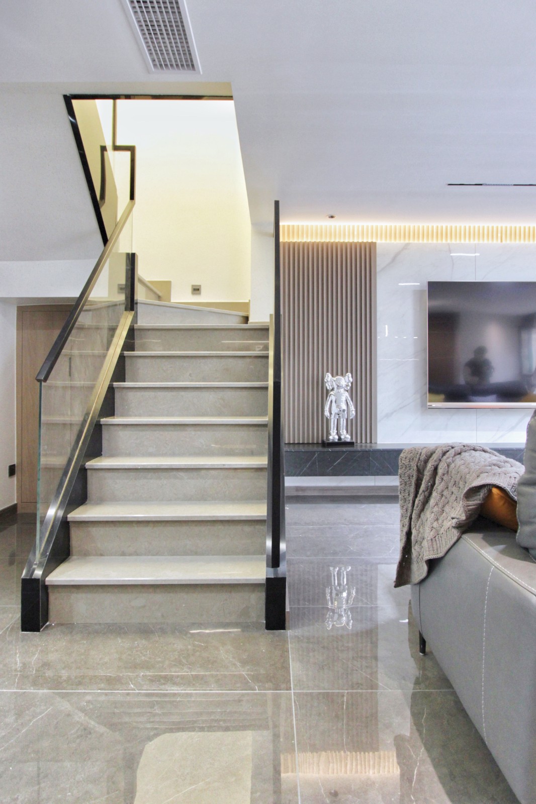 楼梯与客厅自然过渡,同色系瓷砖自然衔接,透明玻璃搭配黑色哑光扶手