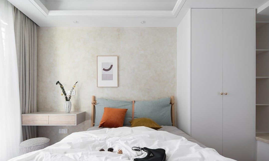 主卧主墙面采用了艺术涂料,蓝色布艺靠枕大床新潮美观,束带融合了皮质