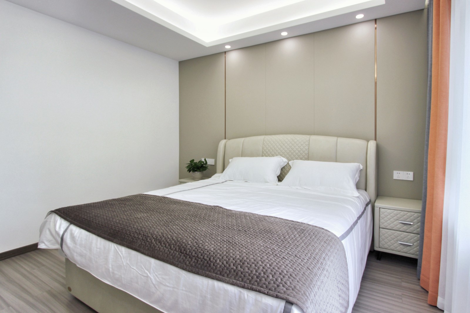 主卧室,设计师用暖色调搭配空间,墙面硬包搭配不锈钢