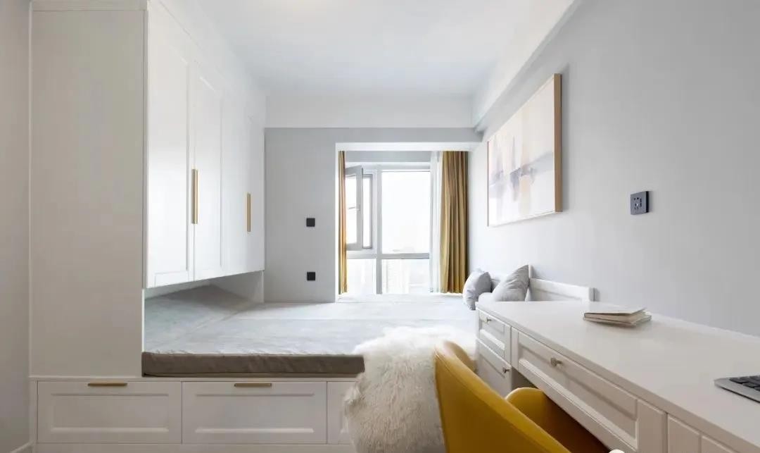 床尾对面定制了一整面的收纳柜,将衣柜,电视柜及梳妆台一体化,让空间