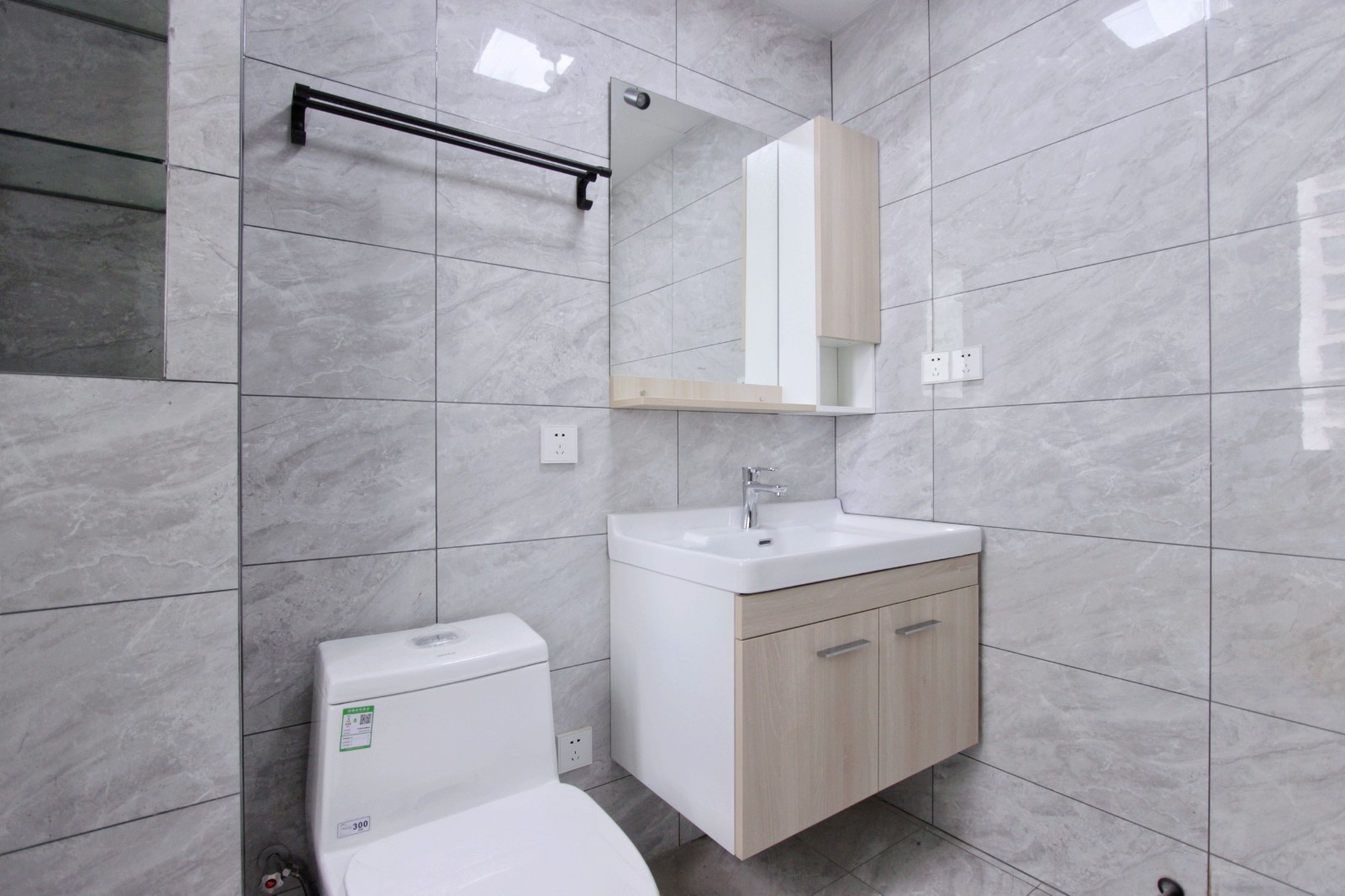 卫生间采用的是宽敞明亮的浅灰色调,通铺大理石纹瓷砖,将干湿区以挡水