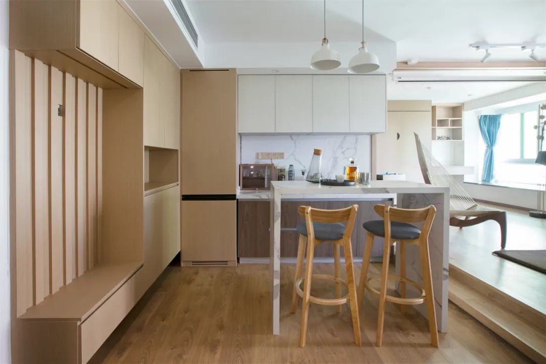 大理石中岛台作为餐桌,搭配上高脚吧椅,后方定制西厨操作台,也让餐厨